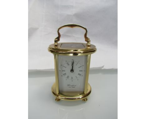 A 20th Century Woodford oval form brass carriage clock, platform escapement with key 