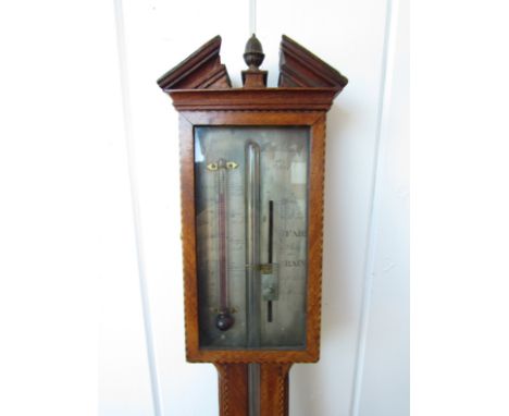 An early 19th Century mahogany and inlaid stick barometer with broken arch top, silvered dial signed F. Molton, open tubed (e