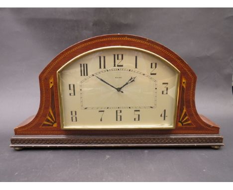 A 1920's mahogany and inlaid mantel clock, arched silvered dial with Arabic numerals, on brass bun feet