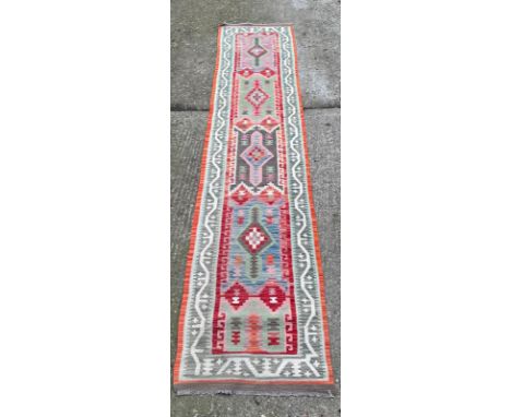 An Aztec pattern runner with geometric border 400cm x 84cm 