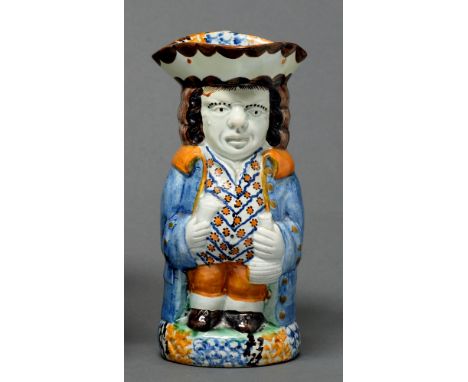 A Prattware toby jug, c1820, modelled standing with figural handle, sponged in a typical blue, green, ochre and manganese pal