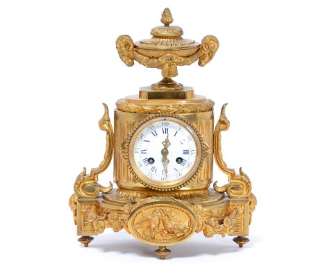A French gilt bronze mantle clock, mounted with an urn with ram's mask handles, convex enamel dial, the base with a pair of l