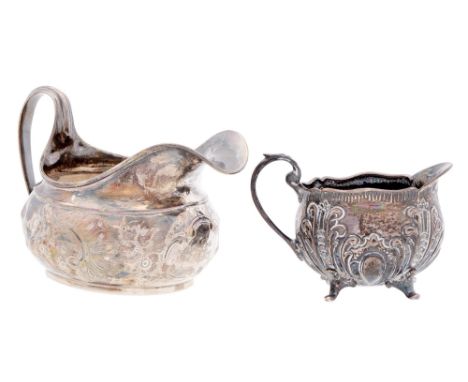 A George III silver cream jug, later chased, 13.5cm l, marks rubbed, London 1805 and a later, smaller silver cream jug, 7oz 1