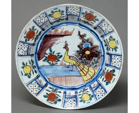 A Delftware dish, possibly Bristol, c1760, painted with a yellow peacock flanked by flowers, 34.5cm diam  A very well preserv