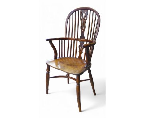 A 19th century yew wood and elm stick back Windsor armchair, with a shaped splat on turned legs united by a crinoline stretch