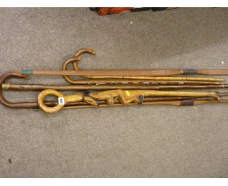 Two vintage bows, a shepherd's crook, a carved African walking stick and two others etc