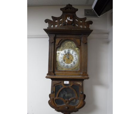 An early 20th century oak cased wall clock with brass dial 