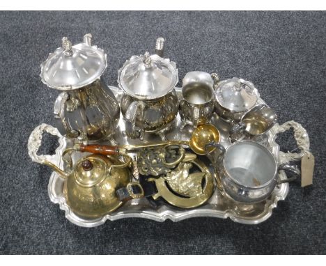 A plated twin handled serving tray, four piece plated tea service, further plated sugar bowl and milk jug and assorted brass 