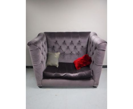 A contemporary high backed settee, upholstered in a mauve button fabric, together with two scatter cushions