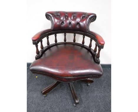 A red button leather captain's armchair 