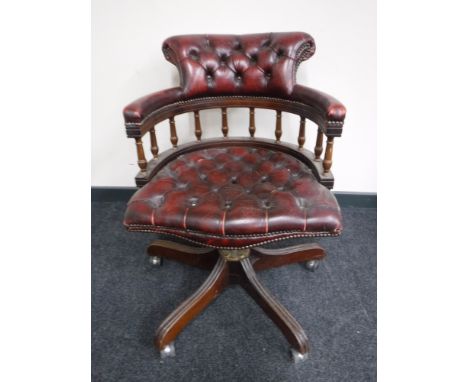 A red button leather Chesterfield swivel captains armchair 