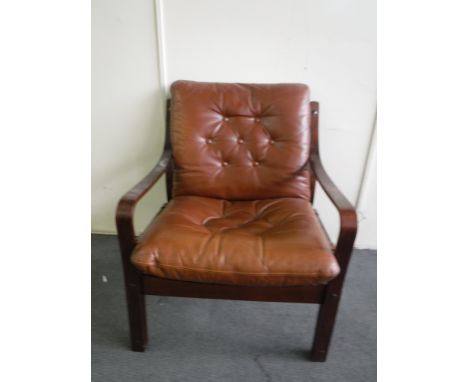 A late 20th century armchair in brown button leather   