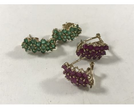 A pair of ruby cluster earrings set in gold, together with a similar pair of emerald earrings CONDITION REPORT: One of the ru