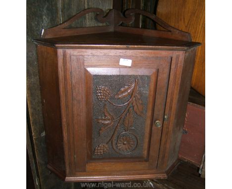 An Edwardian Oak Wall hanging Corner Cabinet, having moulded pediment upstand back, over moulded cornice, over single raised 