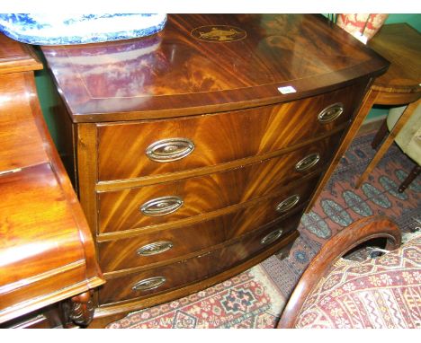 A reproduction flame Mahogany bow fronted Chest of four Drawers having well figured top with central inlaid urn motif, strung