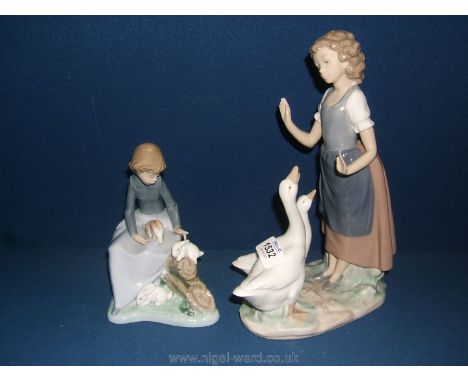 Two Nao figurines, one of a girl teaching the geese, and girl with rabbits