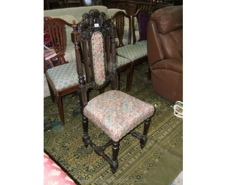 A late 19th c. Oak Hall Chair, Carolinian style, with carved heraldic back flanked by rampant lions, with central pad between