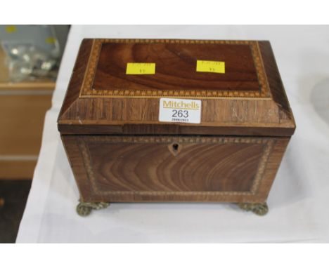 Inlaid tea caddy on brass lion paw feet.