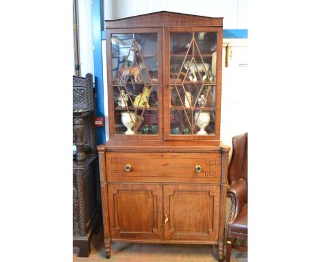 An early 19th century inlaid mahogany secretaire bookcase, architectural pediment, fitted secretaire drawer, two cupboards un