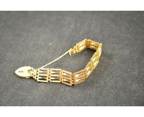 A 9ct gold five bar gate bracelet with padlock clasp and safety chain - approx weight 13g