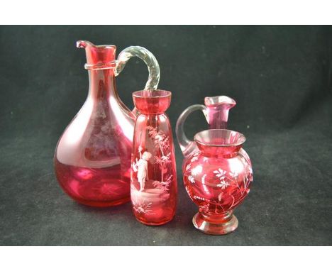 A cranberry glass decanter with clear loop handle - H20cm, a Mary Gregory style jug - H12.5cm and two vases with white enamel