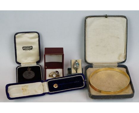 A small group of vintage jewellery to include a 9ct metal core bangle, silver rings, tie pin ...etc. 