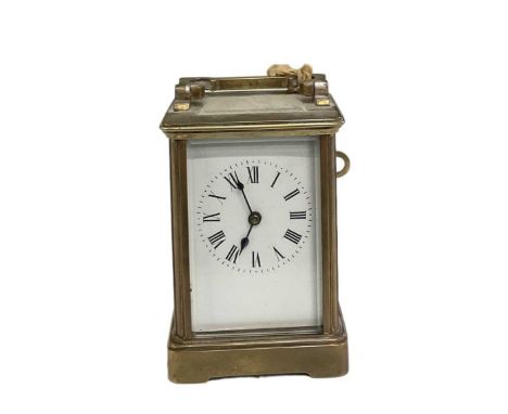 An early 20th century brass cased carriage clock produced by R &amp; Co of Paris, the white enamel dial set with Roman numera