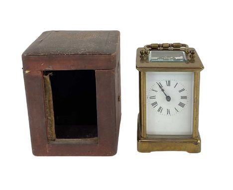 A brass cased carriage clock, the white enamel dial set with Roman numerals, in leather travelling case, overall height in tr