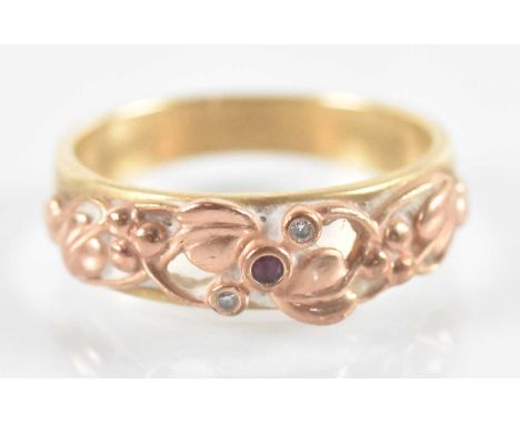 A 9ct yellow gold ring set with central red stone flanked by two white stones, with floral decoration, size W, approx 6g.