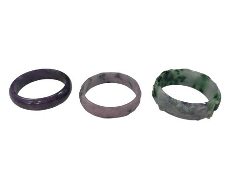 A Chinese carved jadeite bangle, decorated with scrolling foliage and animals, diameter 7cm, and two further lavender jadeite