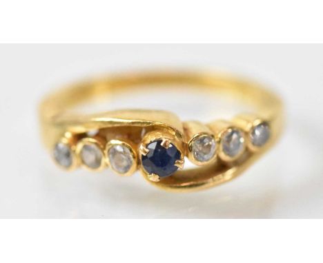 A yellow metal ring set with central blue stone flanked by six small white stones, size J/K, approx 4.3g.