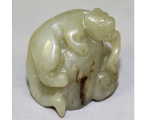 A GOOD 19TH/20TH CENTURY CELADON JADE CARVING OF A CHILONG, standing on rockwork and bearing a frond of lingzhi in its mouth,