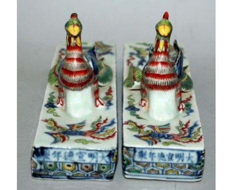 A PAIR OF CHINESE DOUCAI PORCELAIN SCROLL WEIGHTS, each of rectangular form and moulded with a phoenix in high relief, each w