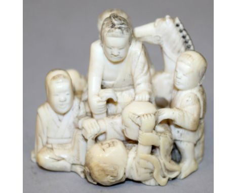 A GOOD QUALITY SIGNED JAPANESE MEIJI PERIOD IVORY OKIMONO OF A GROUP OF PLAYING CHILDREN, a small mask in their midst, one bo