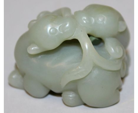 A CHINESE GREEN JADE-LIKE GROUP OF TWO MYTHICAL ANIMALS, holding between them a frond of lingzhi, 2.1in wide & 1.6in high.