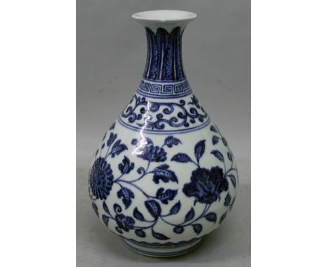 A CHINESE MING STYLE BLUE & WHITE PORCELAIN VASE, the sides of the pear-form body decorated with formal scroll-stemmed foliag