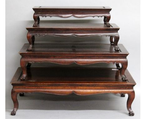 A GRADUATED SET OF FOUR EARLY 20TH CENTURY CHINESE RECTANGULAR HARDWOOD STANDS, with short scroll feet, the largest 22in x 14