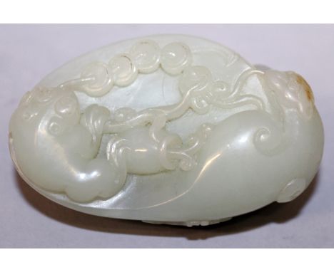 A CHINESE CELADON JADE-LIKE GROUP, of a three-legged toad and a bat linked by a string of 'cash' on top of a pebble-form boul