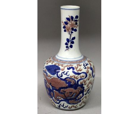 A CHINESE UNDERGLAZE-BLUE & COPPER-RED PORCELAIN VASE, the sides decorated with a repeated design of a buddhistic lion playin