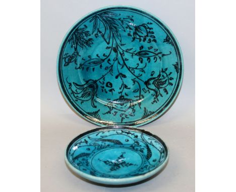 A 19TH/20TH CENTURY PERSIAN KASHAN CERAMIC DISH, decorated in black with a spray of flowers reserved on a turquoise ground, 7