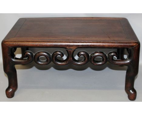 A 19TH/20TH CENTURY CHINESE CARVED HARDWOOD STAND, of rectangular form and with a scroll frieze, 20.5in x 13.25in x 9.8in hig