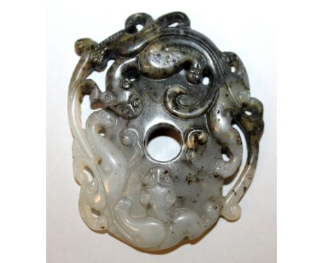 A CHINESE JADE-LIKE GROUP OF TWO CONFRONTING CHILONG, the pierced stone of grey tone with darker inclusions, 2.9in x 2.3in.