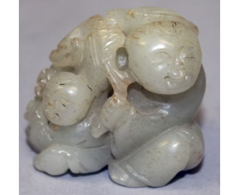 A 19TH/20TH CENTURY CHINESE CELADON JADE GROUP OF TWO BOYS, each seated and holding fronds of lingzhi and blossoms, 1.9in wid