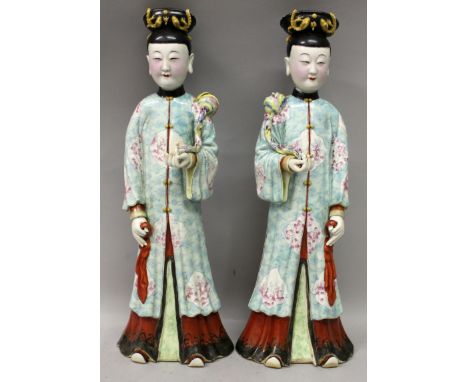 A LARGE MIRROR PAIR OF CHINESE FAMILLE ROSE PORCELAIN FIGURES, each costumed lady holding a sceptre, each unglazed base with 