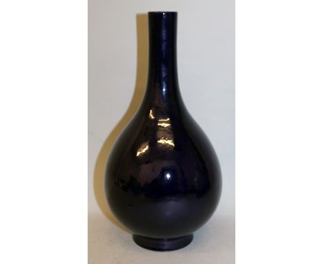 A CHINESE MONOCHROME PORCELAIN BOTTLE VASE, the sides applied with a purple-blue aubergine glaze, the base with an incised Yo