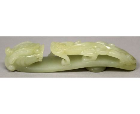 A CHINESE CELADON JADE-LIKE BELT HOOK, of traditional form, 4.3in long.