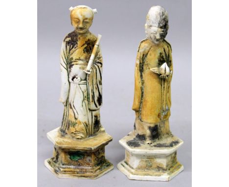 AN UNUSUAL PAIR OF CHINESE KANGXI PERIOD SHIPWRECK BISCUIT PORCELAIN FIGURES OF IMMORTALS, each standing on an elongated hexa