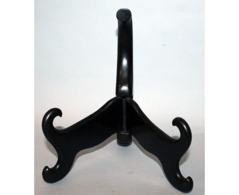 AN EARLY 20TH CENTURY CHINESE HARDWOOD PLATE STAND, with hinged folding scroll-end supports, 9in high.