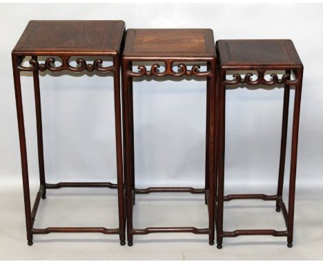 A NEST OF THREE GRADUATED 19TH/20TH CENTURY CHINESE TALL HARDWOOD TABLES, of square section with scroll frieze, the largest 1