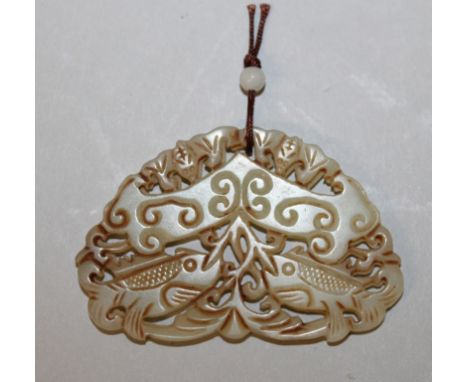 A CHINESE JADE-LIKE RUYI FORM PENDANT, pierced and decorated with sceptres and a pair of fish, 2.6in wide x 1.7in high.